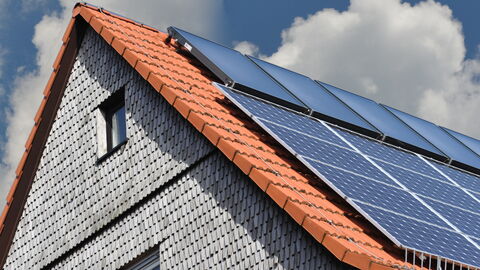 Ein Hausdach mit Photovoltaik- und Solaranlage