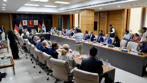 Eine U-förmige Tafel mit Menschen, die daran sitzen. Am Kopfende sitzen Staatsminister Pentz, indische Minister Piyush Goyal und Ministerpräsident Rhein.