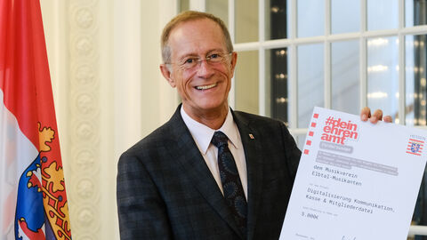 Staatsminister Axel Wintermeyer mit einer Förderurkunde
