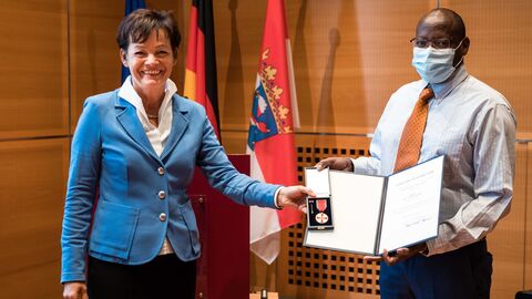 Europaministerin Lucia Puttrich bei der Übereichung der Verdienstmedaille an Dr. James Karanja