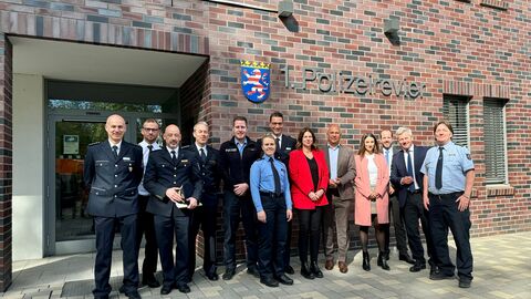 Innenminister Roman Poseck, unter anderem mit Stadtrat Andreas Kowol, Bürgermeisterin Christiane Hinninger, Ordnungsdezernentin Maral Koohestanian, Polizeipräsident Felix Paschek, stellv. Leiter der Polizeidirektion Wiesbaden Sascha Apitz und Revierleiter Marcus Bergner vor Polizeirevier