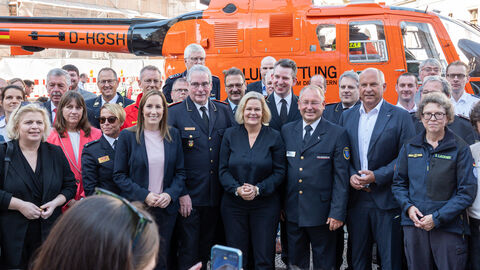 2. Bevölkerungsschutztag  : Bundesinnenministerin Nancy Faeser, Innenminister Roman Poseck, Landtagspräsidentin Astrid Wallmann, Oberbürgermeister Gert-Uwe Mende stehen gemeinsam mit Einsatzkräften vor Rettungshubschrauber